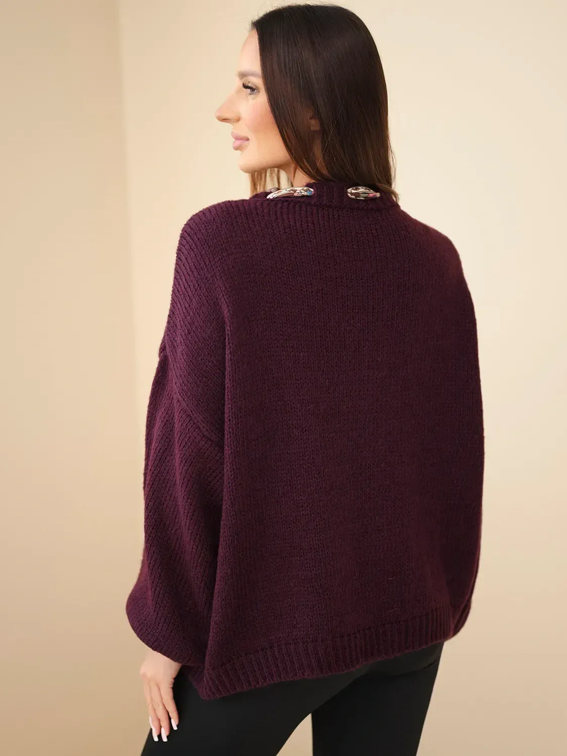 Sweter oversize w kolorze fioletowym, modelka prezentuje tył ubrania.