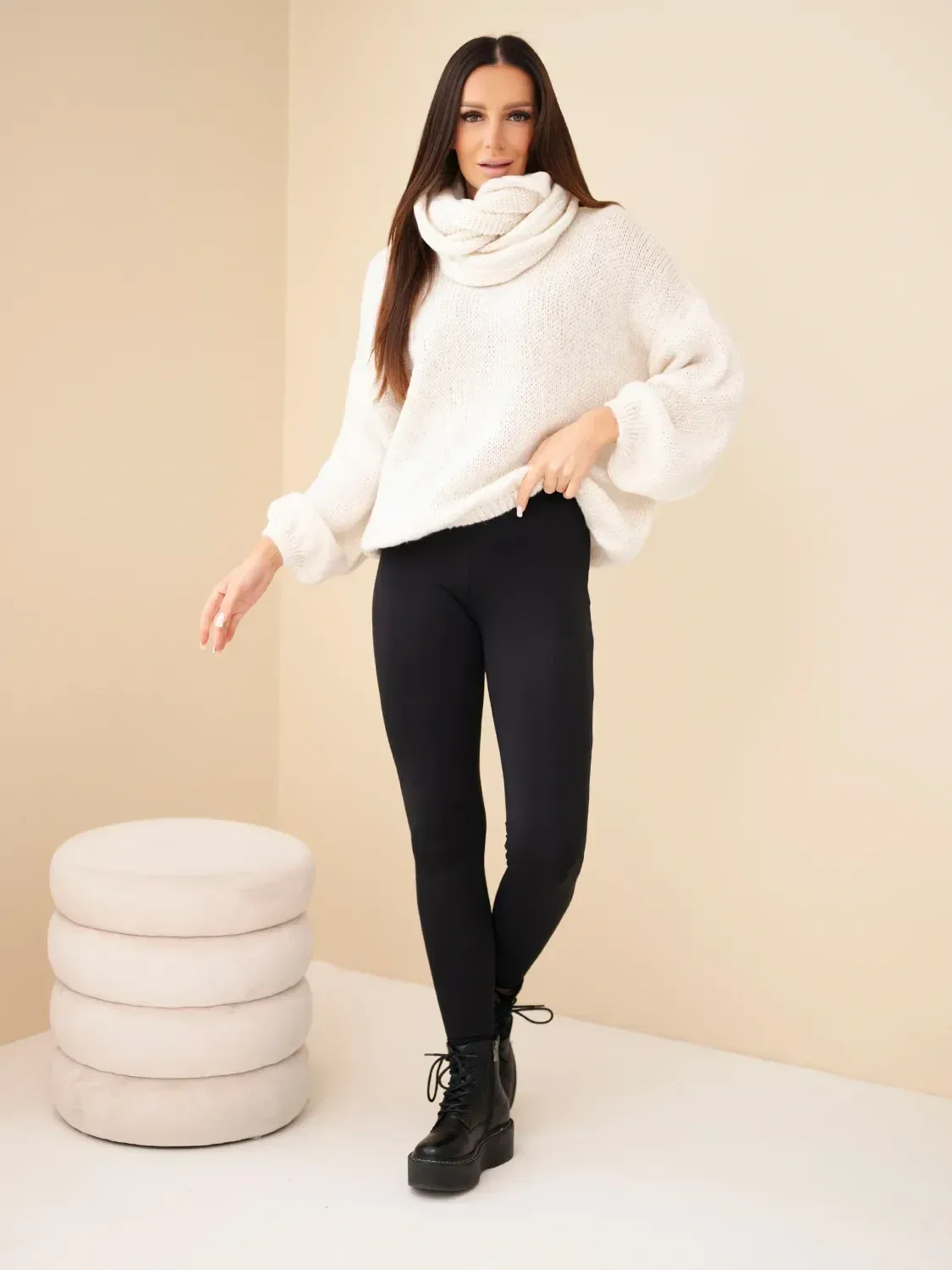 Modelka w białym swetrze oversize i czarnych legginsach, stylowa jesień.