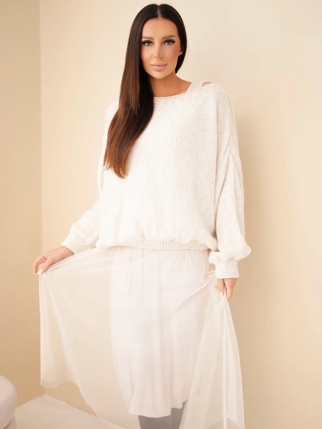 Mazii Fashion женская белая уютная кофта и прозрачная юбка на фоне бежевых стен.